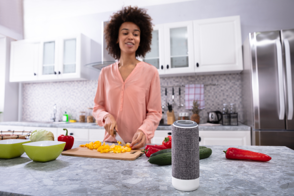 Woman in Kitchen Talking to Smart Speaker